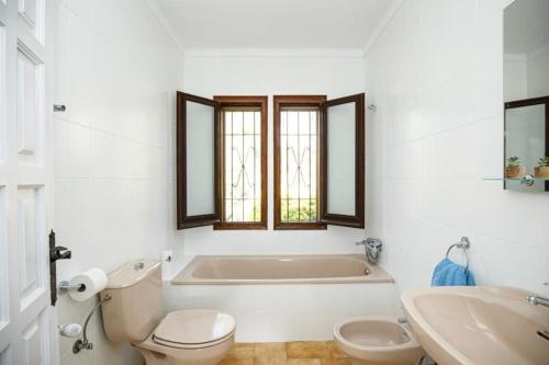 a bathroom with a tub and a toilet and a sink at Villa Boheme Costa Brava in Calonge