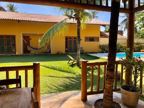 a house with a yard with a pool and palm trees at Pouso do Kite Pousada Flecheiras in Flecheiras