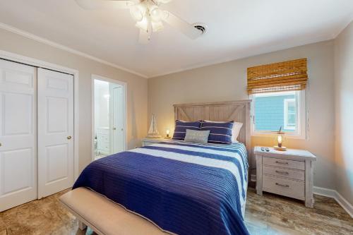 Un dormitorio con una cama azul y una ventana en Smooth Sailing 14105 en Ocean City
