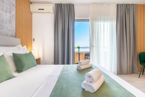 a bedroom with a large bed with towels on it at Apartmani Eterović in Baška Voda