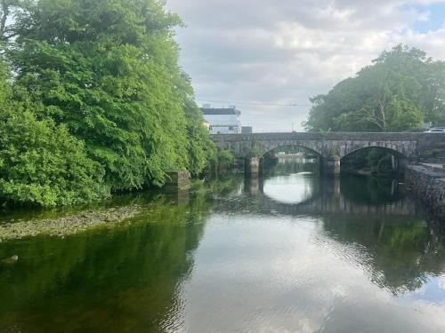 a stone bridge over a river with trees and water at In the country yet close to town in Carterʼs Bridge