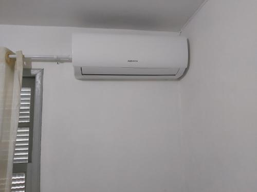 a white air conditioner hanging from the ceiling in a room at Hotel Pousada Girassol in Matinhos