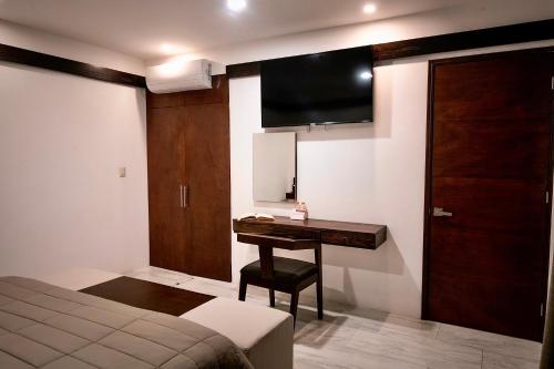 a bedroom with a desk and a tv on the wall at Hotel Casa Cantera in Oaxaca City