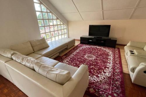 a living room with a couch and a flat screen tv at Spacious Home in Kuala Terengganu in Kuala Terengganu