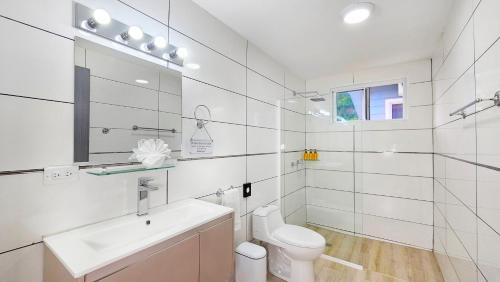 a white bathroom with a sink and a toilet at El Cielo by Villa Alejandro in Boquete