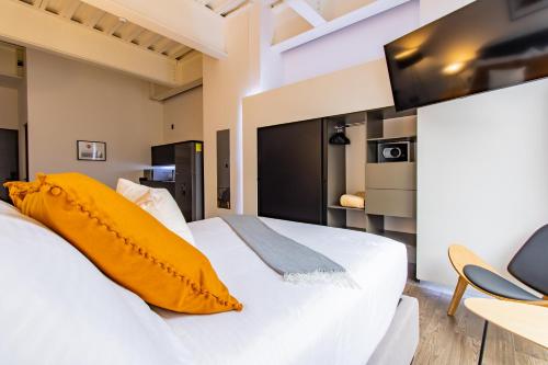 Capitalia - Apartments - Centro Histórico في مدينة ميكسيكو: غرفة نوم بسرير ابيض كبير مع مخدات صفراء