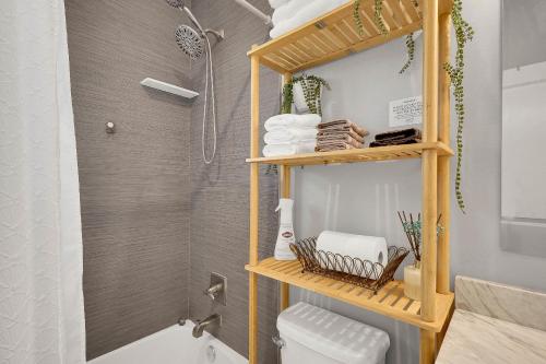 a bathroom with a shower and a toilet and towels at Wellington Garden in West Palm Beach