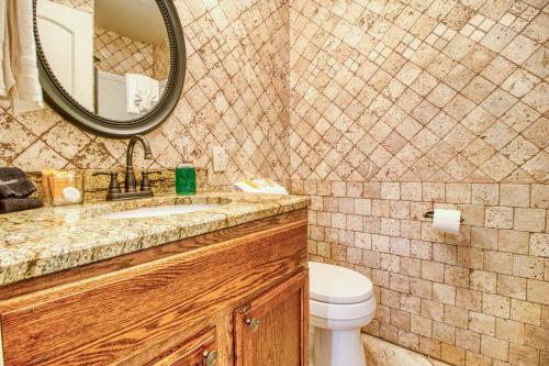 a bathroom with a sink and a mirror and a toilet at Breathtaking Sunsets, Views, Pool, Heaven Awaits! in Gatlinburg