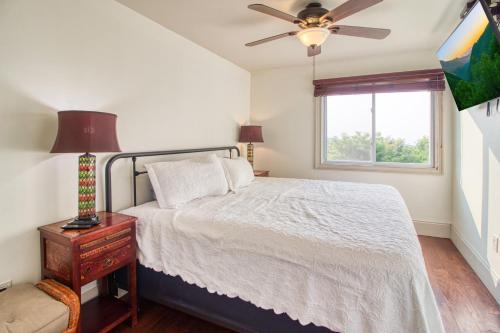 a bedroom with a bed with a ceiling fan and a window at Breathtaking Sunsets, Views, Pool, Heaven Awaits! in Gatlinburg