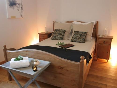 a bedroom with a large wooden bed with a table at Villa with covered terrace in rural Chalais in Chalais