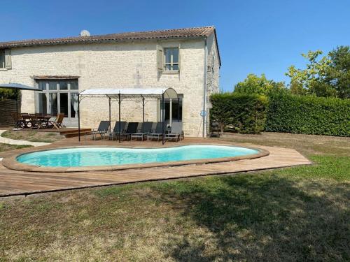 une piscine devant une maison dans l'établissement Villa with covered terrace in rural Chalais, à Chalais