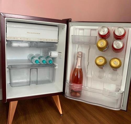 an open refrigerator with a bottle and drinks in it at Pousada Balneário Camboriú in Balneário Camboriú