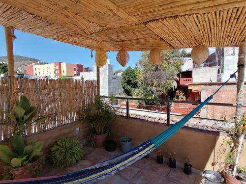a hammock on a balcony with a view at Casa los Arcos Oaxaca in Oaxaca City