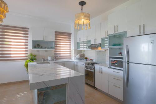 a kitchen with white cabinets and a white refrigerator at Safty Palm Oasis Private Pool & Beach Access in Ain Sokhna