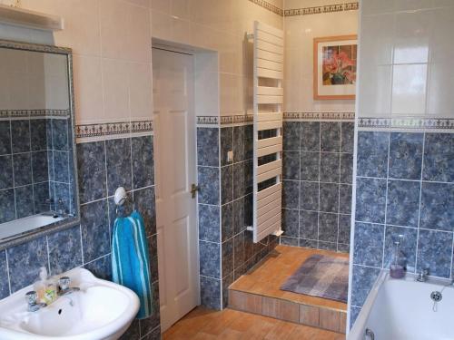 een badkamer met een douche, een wastafel en een bad bij Cosy cottage in Sainte-Marguerite-d'Elle with barbecue in Sainte-Marguerite-dʼElle