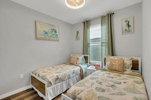 a bedroom with two beds and a window at Wellington Garden in West Palm Beach