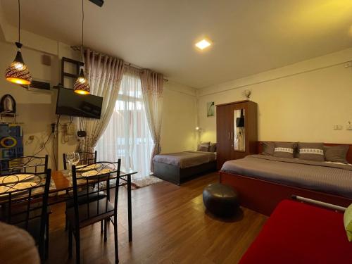 uma sala de estar com uma cama e uma sala de jantar em Breeze Holiday Casa em Nuwara Eliya