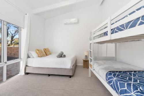 a bedroom with two beds and a bunk bed at Ubuntu by Experience Jervis Bay in Vincentia