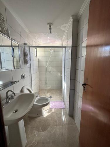 y baño con aseo y lavamanos. en Apartamento no Centro Foz do Iguaçu 130 mt, en Foz do Iguaçu