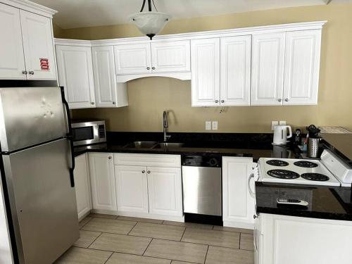 a kitchen with white cabinets and a white refrigerator at Home Away From Home in Stanley Bridge