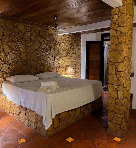 a stone walled bedroom with a bed in a room at Locanda Samara Beach in Sámara