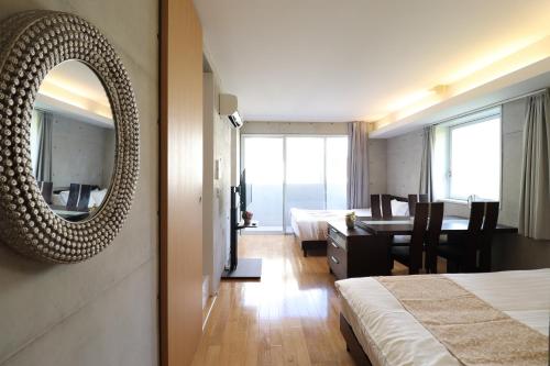 a hotel room with a mirror and a dining room at Ideal Tennoji イデアール天王寺 in Osaka
