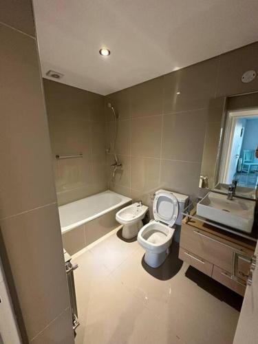 a bathroom with a toilet and a tub and a sink at Dpto en fontanas del sur, excelentes amenities y muy tranquilo in Cordoba