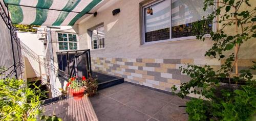 - un balcon d'une maison avec un banc et des fleurs dans l'établissement Departamento Alicia, à San Rafael