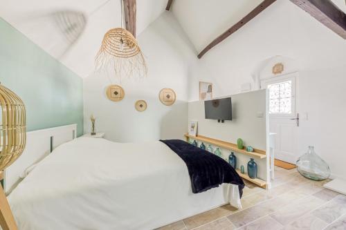 1 dormitorio blanco con 1 cama y TV en Le Studio Green Lime, en Carrières-sous-Poissy