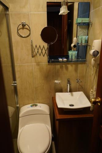 a small bathroom with a toilet and a sink at Hotel Colonial - Casa Francisco in Quito