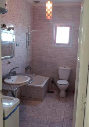 a bathroom with a tub and a toilet and a sink at شقة بشارع حزيمة in Damanhûr