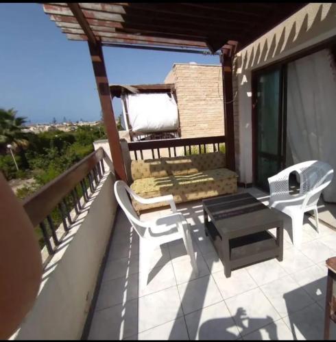 d'une terrasse avec des chaises et une table sur un balcon. dans l'établissement شقة بشارع حزيمة, à Damanhûr