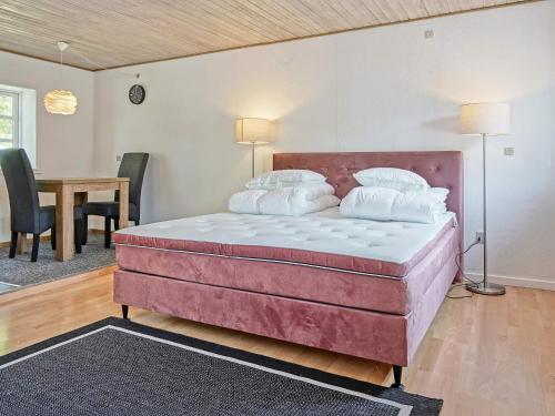 ein großes Bett in einem Zimmer mit einem Tisch und Stühlen in der Unterkunft Holiday home Rønne VI in Rønne