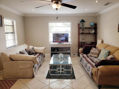 a living room with two couches and a coffee table at OCEAN VACATION BREEZE in Lantana