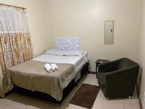 a small bedroom with a bed and a chair at HOTEL SÃO LUÍS in Uruguaiana