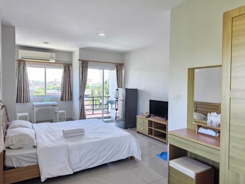 a bedroom with a bed and a desk and a mirror at Sawairiang Place in Nakhon Ratchasima