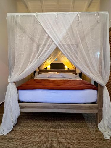 a bed with a canopy in a room at La Villa By Ferdi'Nan in Grand-Bourg
