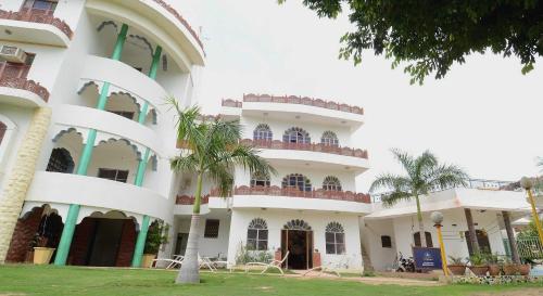 un grande edificio bianco con palme di fronte di OYO Flagship Ranibagh Palace a Jodhpur