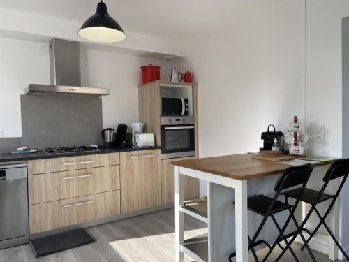 - une cuisine avec une table en bois et un comptoir dans l'établissement Maison à Erdeven: 4 pièces, 90m², plage à 1km, terrasse, jardin clos, idéal pour familles et randonnées - FR-1-397-41, à Erdeven