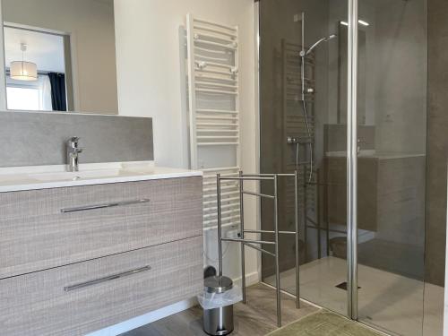 une salle de bain avec une douche en verre et un lavabo dans l'établissement Maison à Erdeven: 4 pièces, 90m², plage à 1km, terrasse, jardin clos, idéal pour familles et randonnées - FR-1-397-41, à Erdeven