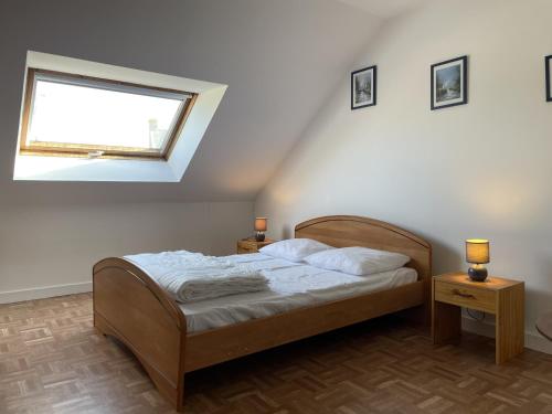 une chambre avec un lit avec deux tables de nuit et une fenêtre dans l'établissement Maison à Erdeven: 4 pièces, 90m², plage à 1km, terrasse, jardin clos, idéal pour familles et randonnées - FR-1-397-41, à Erdeven