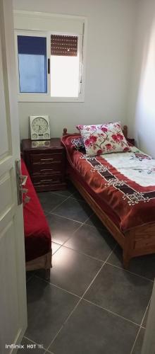 Schlafzimmer mit einem Bett, einem Schreibtisch und einem Fenster in der Unterkunft Qamars'geusts in Al Hoceïma