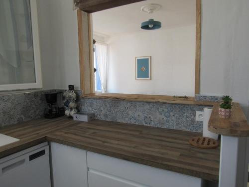 eine Küche mit einer Holzoberfläche und einem Spiegel in der Unterkunft Maison La Faute-sur-Mer, 6 pièces, 10 personnes - FR-1-194-248 in La Faute-sur-Mer