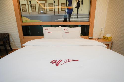 a bed in a hotel room with a sign on it at Mokpo Well hotel in Mokpo