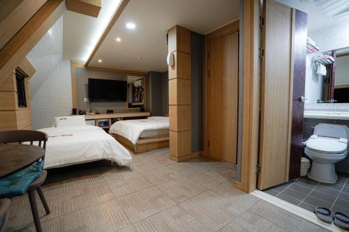 a hotel room with two beds and a toilet at Mokpo Well hotel in Mokpo