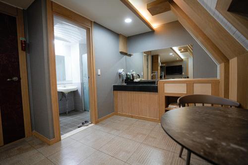 a kitchen and dining room with a table and a sink at Mokpo Well hotel in Mokpo