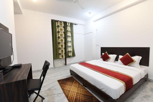 - une chambre avec un lit, un bureau et une télévision dans l'établissement OYO Ooak Hotels Delta 1, à Greater Noida