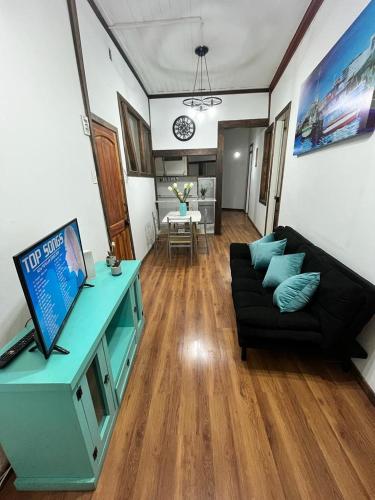 uma sala de estar com um sofá e uma televisão em Casa Valparaíso em Valparaíso