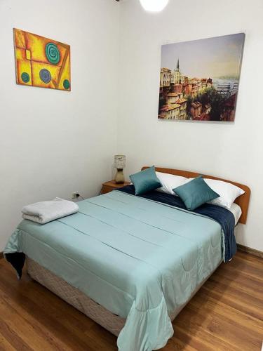 a bedroom with a large bed with blue sheets at Casa Valparaíso in Valparaíso