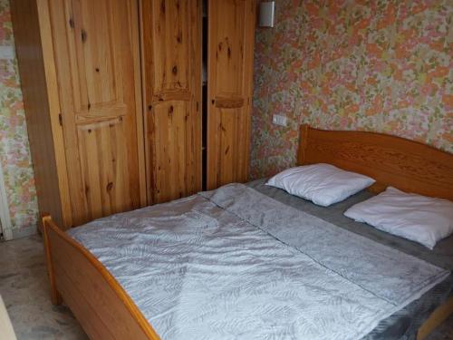 ein Schlafzimmer mit einem Holzbett mit zwei Kissen in der Unterkunft Appartement Argelès-sur-Mer, 3 pièces, 4 personnes - FR-1-732-7 in Argelès-sur-Mer